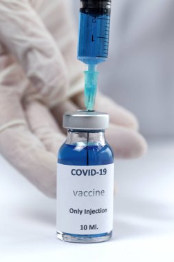 COVID-19 aşısı araştırmacıların elinde tanınmayan kadın doktor Coronavirus aşısı için şırınga ve şişe tutuyor. Corona virüsü tedavisi kavramı