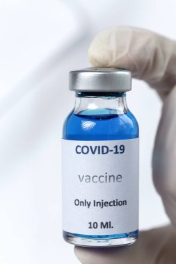 COVID-19 aşısı araştırmacıların elinde tanınmayan kadın doktor Coronavirus aşısı için şırınga ve şişe tutuyor. Corona virüsü tedavisi kavramı