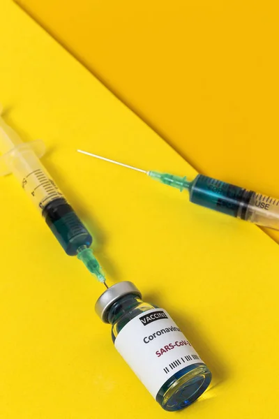 テストCovid 19ワクチンで透明ガラスのバイアル カラフルな背景に注射器付き 選択されたフォーカス — ストック写真