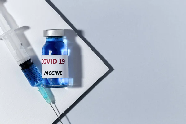 テストCovid 19ワクチンで透明ガラスのバイアル 上からカラフルな背景の注射器付き フラットレイ — ストック写真