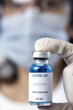COVID-19 aşısı araştırmacıların elinde tanınmayan kadın doktor Coronavirus aşısı için şırınga ve şişe tutuyor. Corona virüsü tedavisi kavramı