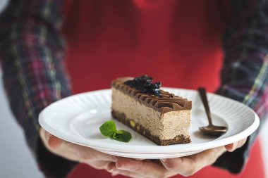 Renkli arka planda nane yaprakları olan Fransız hamur işleriyle tanınmayan kadın elleri.