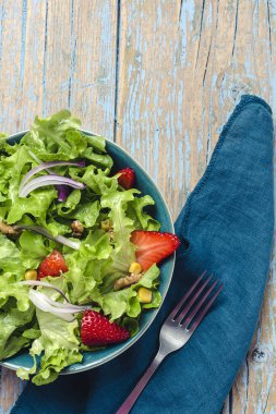 Marullu, çilekli, kırmızı soğanlı, mısırlı, zeytinyağlı ve cevizli ev yapımı salata. Vejetaryen gıda konsepti