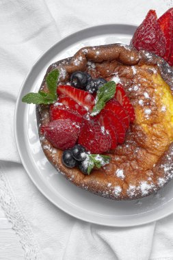 Yukardan gelen yaban mersinli, üzümlü, çilekli ve nane yapraklı ev yapımı cheesecake. Düz yatıyordu