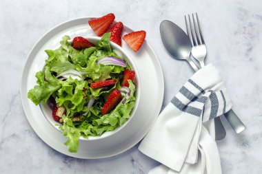 Marullu, çilekli, kırmızı soğanlı, mısırlı, zeytinyağlı ve cevizli ev yapımı salata. Vejetaryen gıda konsepti