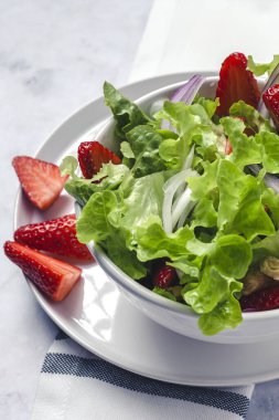 Marullu, çilekli, kırmızı soğanlı, mısırlı, zeytinyağlı ve cevizli ev yapımı salata. Vejetaryen gıda konsepti