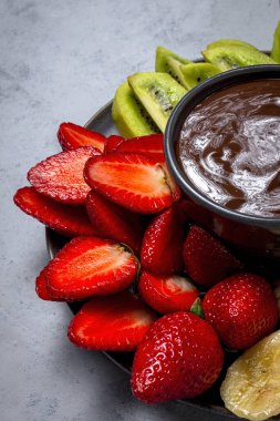 Yemeye hazır çikolatalı Fruits tabağı. Sağlıklı gıda konsepti. Çilek, mango, muz ve kivi.