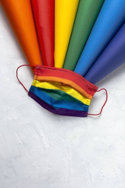 LGBT arka planında gökkuşağı renkli koruyucu yüz maskesi var. Düz yatıyordu. COVID-19 virüsü