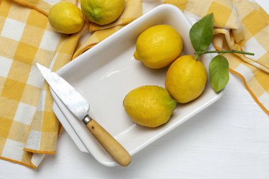 Yukarıdan beyaz arka planda yeşil nane yapraklı taze limonlar. Düz yatıyordu