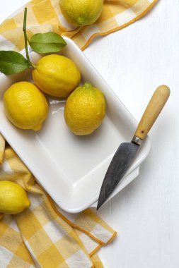 Yukarıdan beyaz arka planda yeşil nane yapraklı taze limonlar. Düz yatıyordu