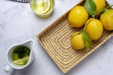 Yeşil nane yapraklı taze limonlar yukarıdan mermer arka planda. Düz yatıyordu