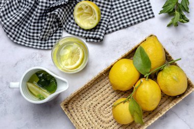 Yeşil nane yapraklı taze limonlar yukarıdan mermer arka planda. Düz yatıyordu