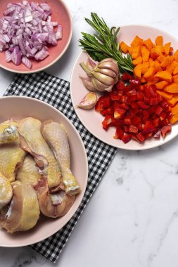 Çiğ bira güveci tavuk tarifi için malzemeler. Tavuk, soğan, havuç, sarımsak, kırmızı biber ve aromatik otlar.