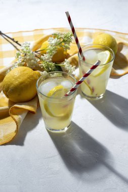Buzlu ev yapımı cam limonata ve beyaz arka planda gün ışığında nane şekeri.