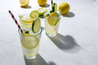 Buzlu ev yapımı cam limonata ve beyaz arka planda gün ışığında nane şekeri.