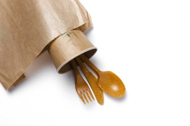 Plastik tek kullanımlık sofra takımı, çatallar, kaşıklar, beyaz arka planda bardaklar. Çevreye önem vermek. Sorun geri dönüşüm. Tekrar kullan. Metin için yer.