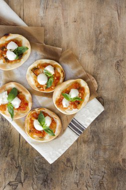 Domates, mozzarella ve fesleğenli ev yapımı mini pizza. Geleneksel İtalyan yemeği.