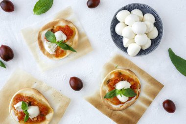 Domates, mozzarella ve fesleğenli ev yapımı mini pizza. Geleneksel İtalyan yemeği.