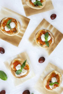 Domates, mozzarella ve fesleğenli ev yapımı mini pizza. Geleneksel İtalyan yemeği.