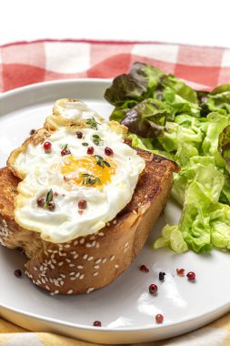 Yukardan beyaz arka planda brioche ve marul salatası ile ev yapımı sahanda yumurta.