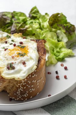 Yukardan beyaz arka planda brioche ve marul salatası ile ev yapımı sahanda yumurta.
