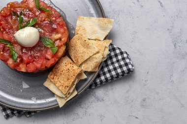 Mozzarella ile ev yapımı domates carpaccio salatası, zeytinyağı ve Arap ekmeğiyle fesleğen. Sağlıklı gıda konsepti