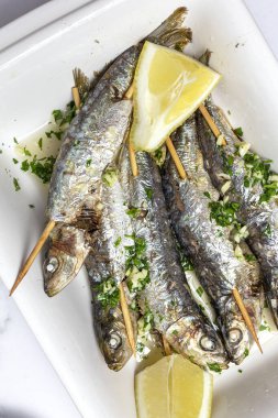 Ev yapımı sarımsaklı, zeytinyağlı, taze maydanozlu ve limonlu sardalya. Sağlıklı yiyecek kavramı.