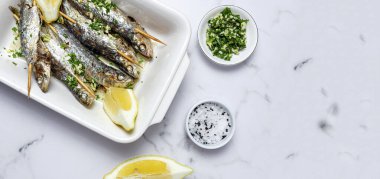 Ev yapımı sarımsaklı, zeytinyağlı, taze maydanozlu ve limonlu sardalya. Sağlıklı yiyecek kavramı.