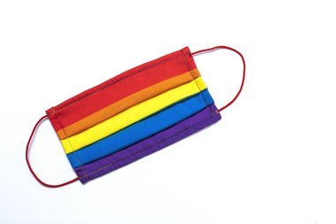 LGBT arka planında gökkuşağı renkli koruyucu yüz maskesi var. Düz yatıyordu. COVID-19 virüsü