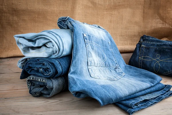 Calça jeans azul na mesa de madeira — Fotografia de Stock