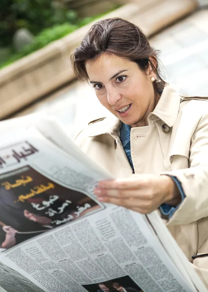 Brunette vrouw lezen van de krant — Stockfoto