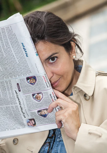 Mooie brunette vrouw lezen van de krant — Stockfoto