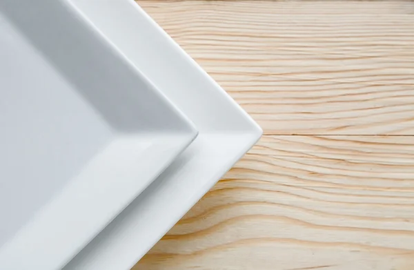 Witte platen over houten tafel vierkant — Stockfoto