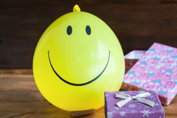 Žlutá bublina s úsměvem a dárkový box — Stock fotografie
