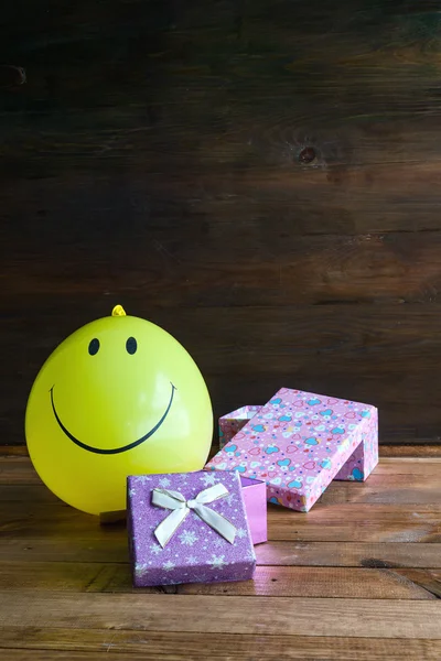 Ballon jaune avec sourire et boîte cadeau — Photo