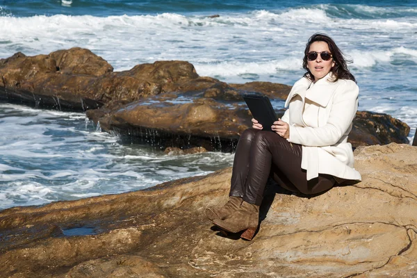 Donna attraente in riva al mare con una tavoletta — Foto Stock