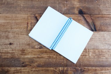 Açık Not Defteri ile boş sayfaları ahşap bir masa üzerinde döşeme