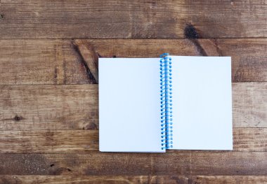 Açık Not Defteri ile boş sayfaları ahşap bir masa üzerinde döşeme