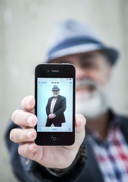 Attractive old man with beard and hat talking on phone — Stock Photo, Image