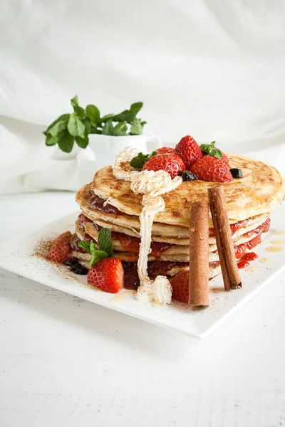 White plate full of pancakes with raspberries strawberries blueb — Stock Photo, Image