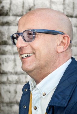 Beyaz arka plan ile gülümseyen gözlüklü Kılsız adam