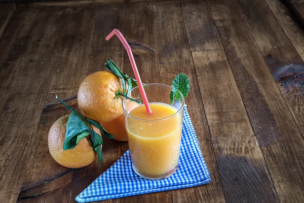 Juice of fresh oranges on old table — Stock Photo, Image