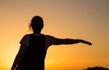 gün batımında sahilde Yoga uygulamak siluet genç kadın.