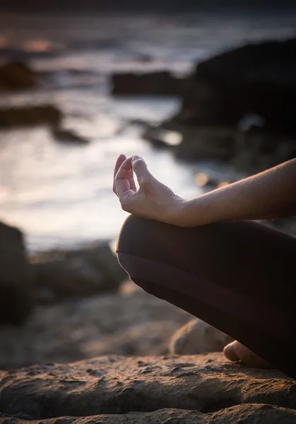 Silhouette giovane donna che pratica yoga sulla spiaggia al tramonto . — Foto Stock