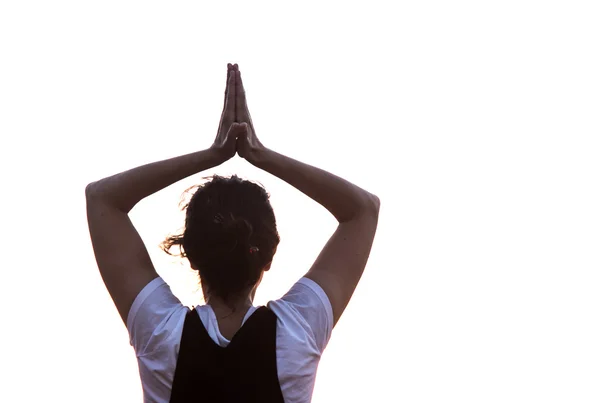 Silhouette giovane donna che pratica yoga sulla spiaggia al tramonto . — Foto Stock