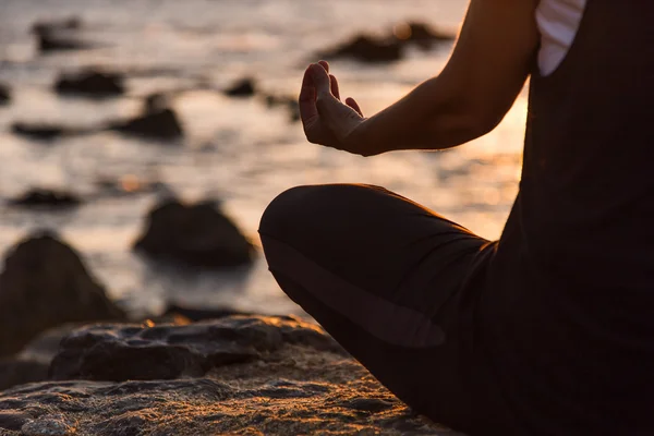 Silhouette giovane donna che pratica yoga sulla spiaggia al tramonto . — Foto Stock