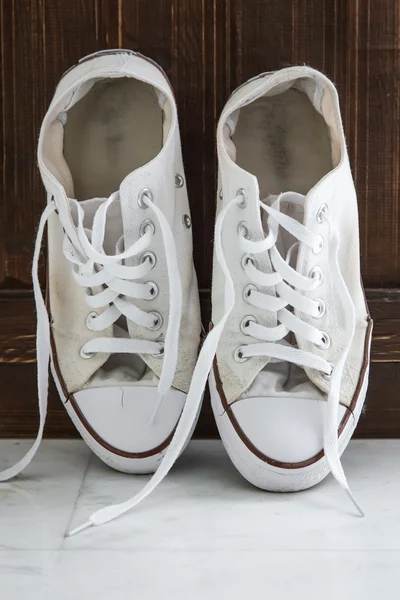 Retro sneakers left on wooden floor — Stock Photo, Image