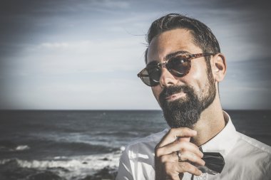 Hipster adam sakal ve şapka sahilde