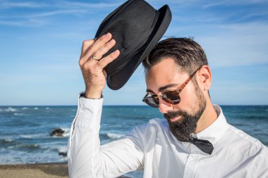 Hipster adam sakal ve şapka sahilde