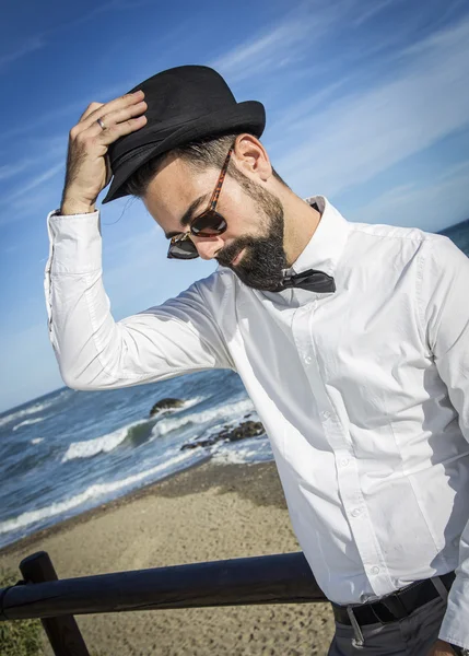Hipster adam sakal ve şapka sahilde